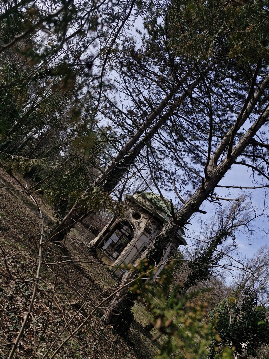 ein verfallener Pavillion versteckt abseits der Wege eines Friedhofs