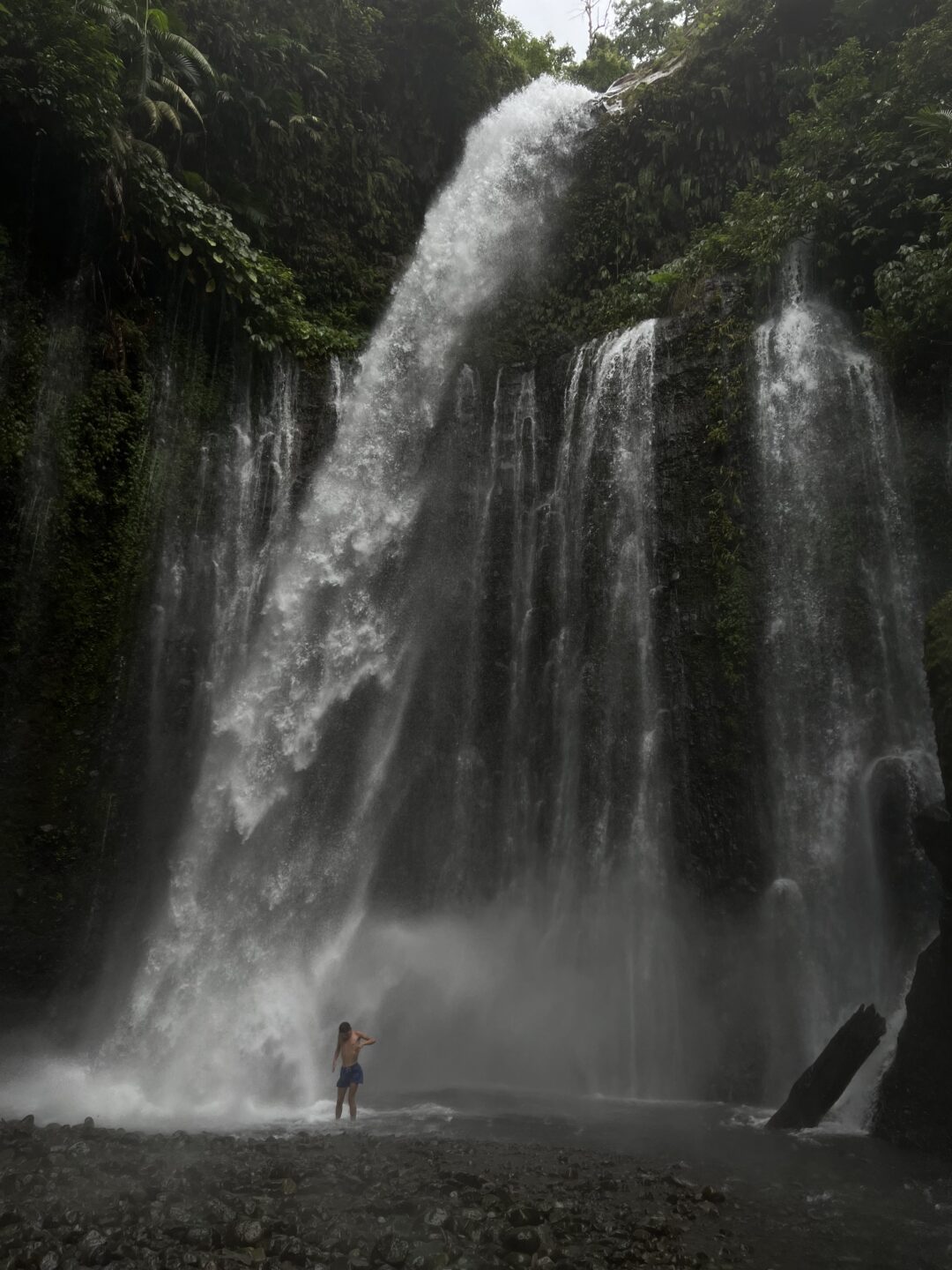 Mann unter Wasserfall