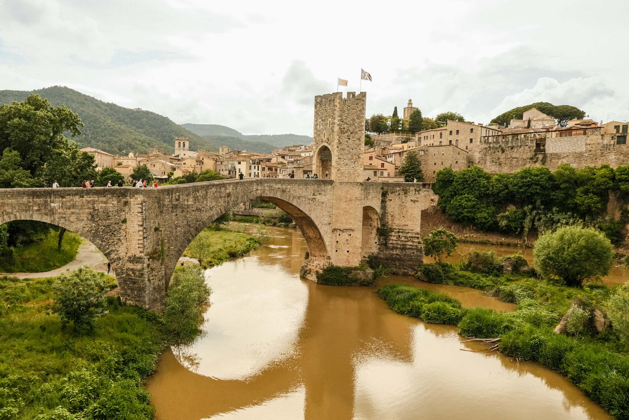 "Living La Vida Loca" in Barcelona 11 IMG 8229 Stone bridge with a tower over a river, and a medieval city in the background.